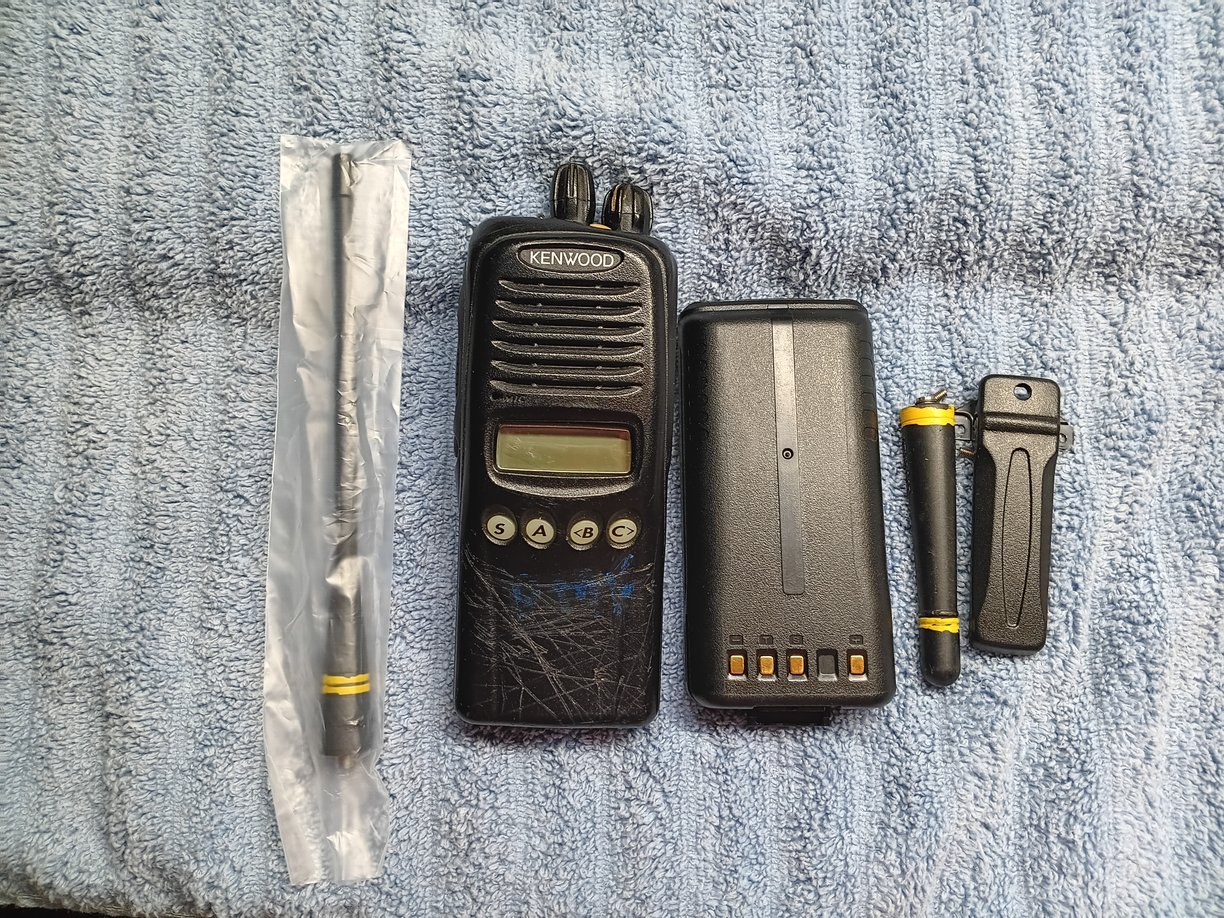 Front view of Kenwood TK-3180 radio showing screen, battery, antenna's & clip